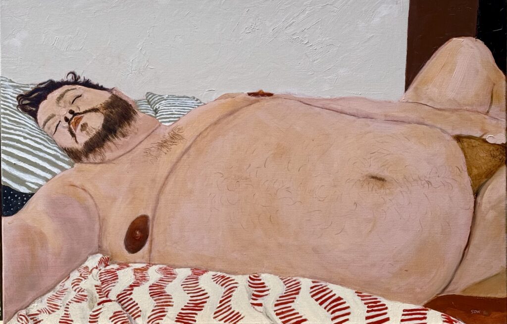 Portrait of Keven, naked, lying on a handmade Hmong blanket and striped pillows.